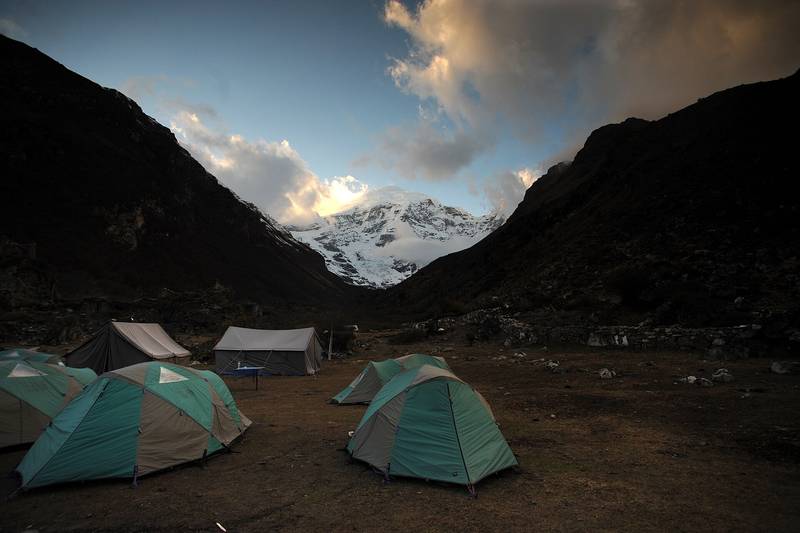Green tents at Jangothang below a snow peak