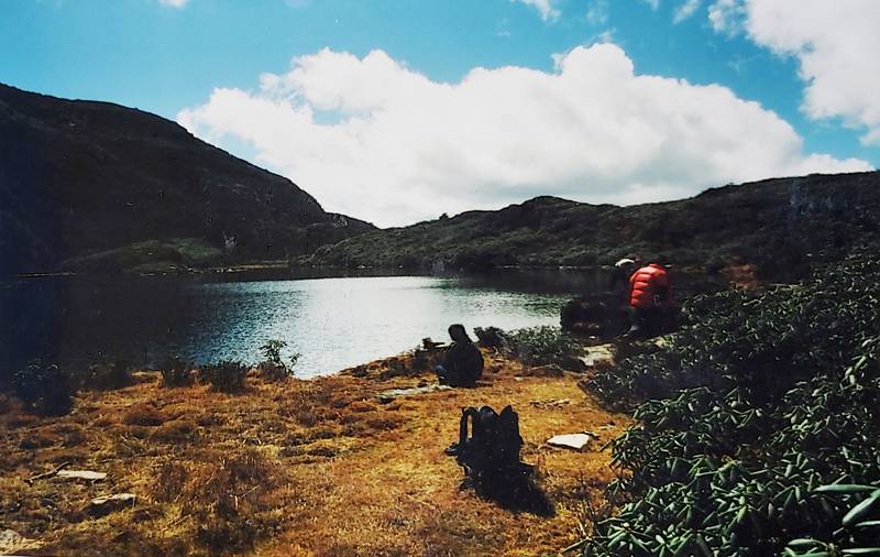 Trekkers resting above Jimilang Tsho, a lake on the Druk Path
